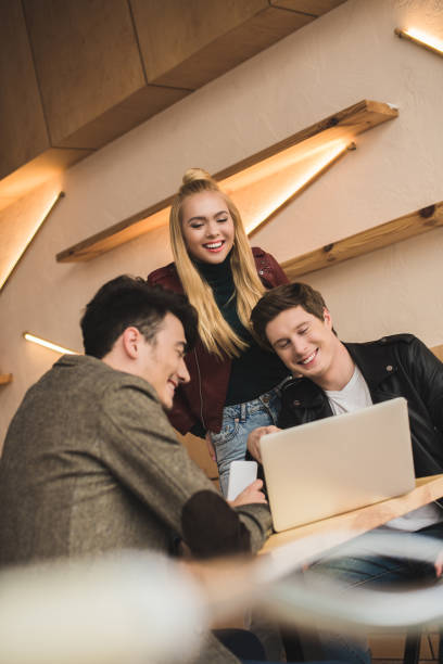 istock Friends laughing and looking at laptop 907857870