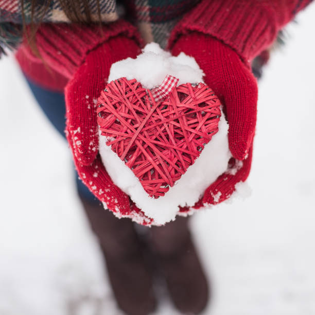 istock Hands in woolen mittens holding red heart 907857994
