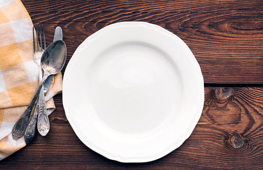 Empty Plate with Knife and Fork on Kitchen Table