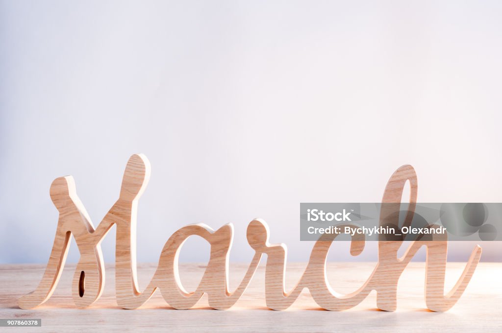 Word month of MARCH carved in wood with light background. Beginning of springtime. Spring hello concept Word month of MARCH carved in wood with light background. Beginning of springtime. Spring hello concept. Greeting Stock Photo