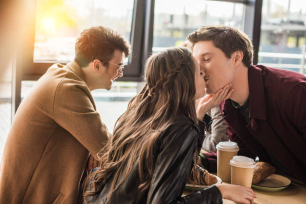 istock heterosexual couple kissing at cafe 907860872