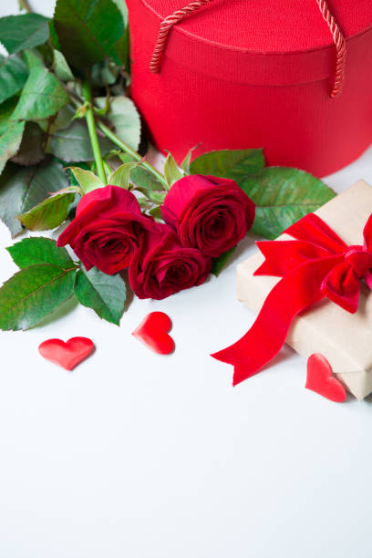 istock Valentines day or engagement marriage celebration concept with red roses and gift box with luxury ribbon bow 907863076