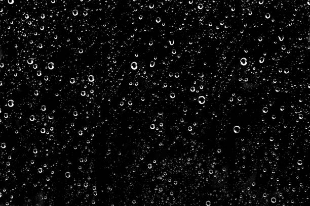 Hundreds of white rain drops on a glass window Hundreds of white rain drops on a glass window with a black background black glass surface stock pictures, royalty-free photos & images