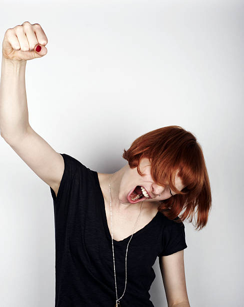 portrait of woman cheering - human fist photos et images de collection
