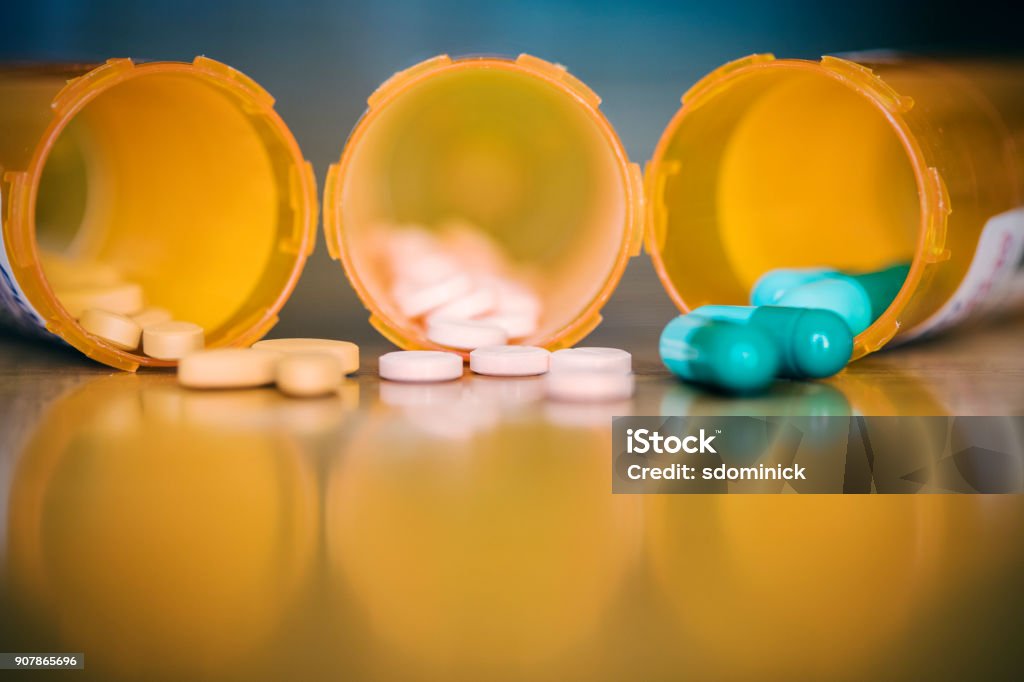 Mixing Medications Three open bottles of prescription medication. Medicine Stock Photo