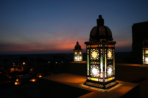 Wall-mounted outdoor lamp illuminated by a narrow beam of light.