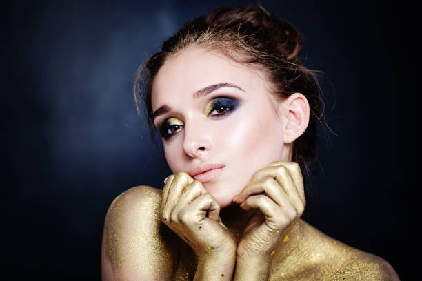 istock Glamorous Woman with Golden Makeup on Blue Background 907869246