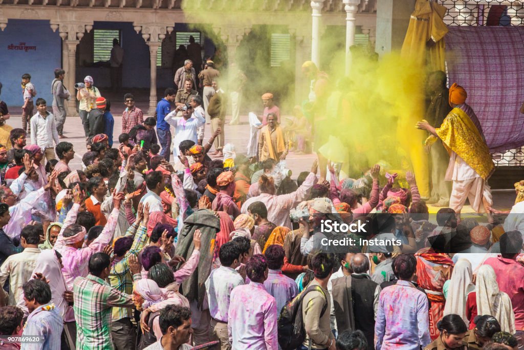 In a temple outdoor part, of Mathura district, the crowd is celebrating Holi festival. Real people and travel photography. Adult Stock Photo