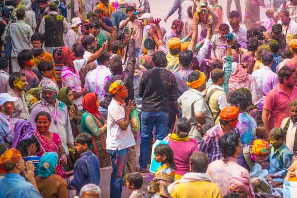 Photo of In a temple outdoor part, of Mathura district, the crowd is celebrating Holi festival.