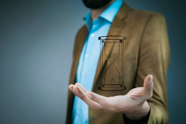 istock glass hour cursor on male hand 907869826