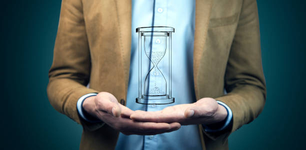 istock glass hour cursor on male hand 907869836