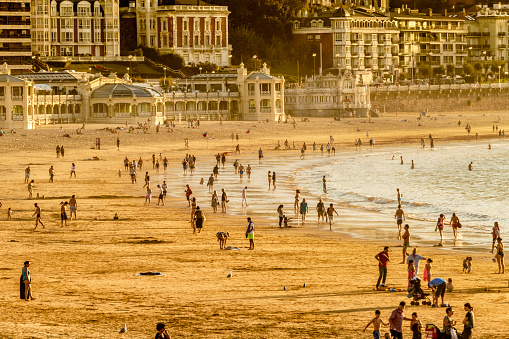 Crowded Summer Beach at sunset in La Concha beach. Bay of Biscay San Sebastian, Spain