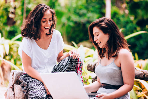istock Two young women friends using laptop outdoors 907871316
