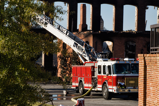 A fire and EMS truck is parked outside of a burnt down brick industrial building. This was shot at the Bibb City textile mill fire near Columbus GA.