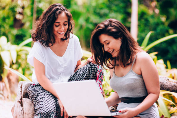 istock Two young women friends using laptop outdoors 907871726