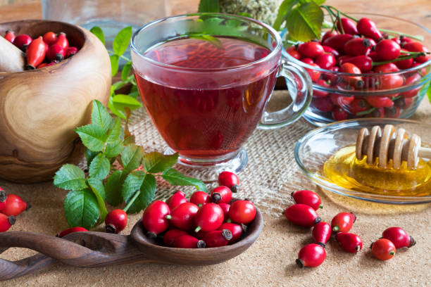 istock Fresh rose hips, rose hip tea and honey on a wooden table 907875438