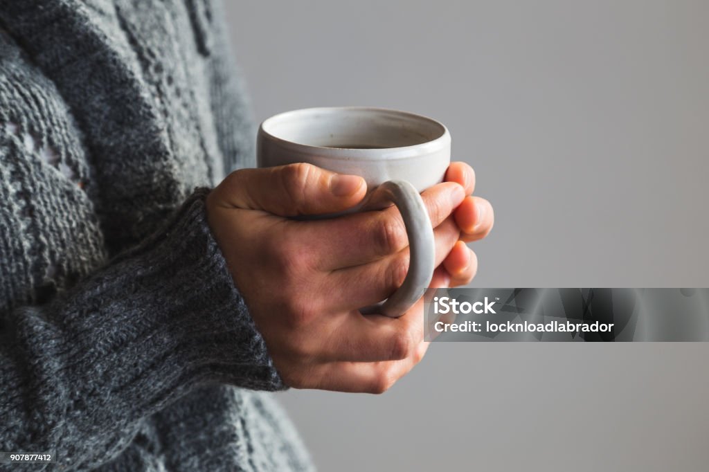 Vrouw in wollige grijze trui houden van warm kopje thee - Royalty-free Hand Stockfoto