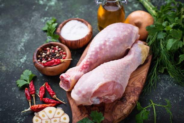 istock Raw chicken legs with spices and garlic. 907878350