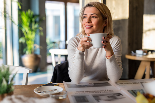 Gorgeous blonde woman holding cup of coffee