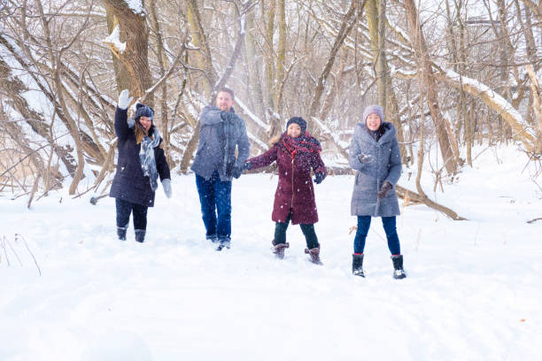 istock Group Of Young People Throwing Snowballs At The Camera 907880732