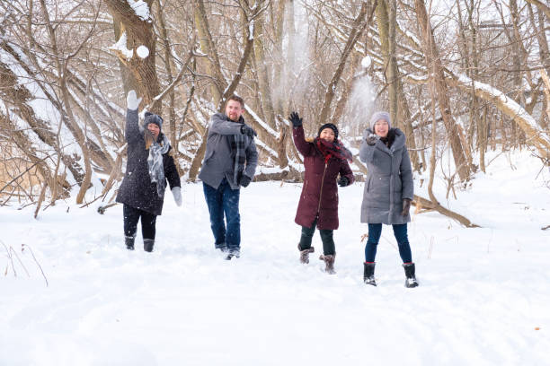 istock Group Of Young People Throwing Snowballs At The Camera 907880748