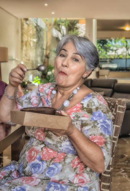 istock Easter Celebration - Grandmother Tasting Chocolate Eggs 907882934