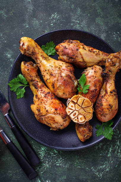 istock Grilled chicken legs with spices and garlic. 907883252