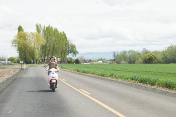 istock Woman riding scooter in country 907883926