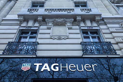 Logo of Tag Heuer on their main shop on Champs Elysees avenue in Paris, France, during a cloudy afternoon. Tag Heuer is a Swiss manufacturer of luxury accessories, mainly watches but as well fashion devices