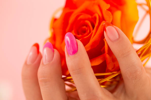 Woman With Polished Nails Holding a Rose Decoration.