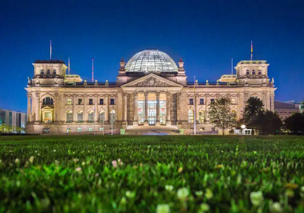 Panoramic view of famous Reichstag building, seat of the German Parliament (Deutscher Bundestag), in twilight during blue hour at dusk, Berlin, Germany