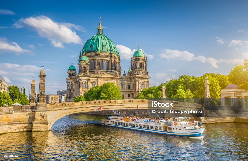 Berlin Cathedral with ship on Spree river at sunset, Berlin, Germany Beautiful view of historic Berlin Cathedral (Berliner Dom) at famous Museum Island with ship passing Friedrichsbrucke bridge on Spree river in golden evening light at sunset in summer, Berlin, Germany Berlin Stock Photo
