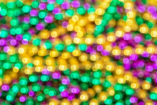 Out of focus background of shiny and colorful Mardi Gras beads