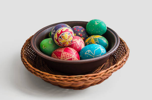 istock colorful painted Easter eggs in a woven straw basket isolated on white background 907888748