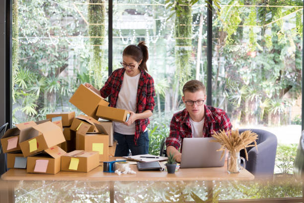 startup small business owner working with computer at workplace. freelance man & woman seller check product order, packing goods for delivery to customer. Online selling, e-commerce, shipping concept inicio pequeño empresario trabajando con la computadora en el lugar de trabajo. hombre independiente y vendedor de mujer compruebe orden del producto, mercancías para la entrega del embalaje. online venta, comercio electrónico, envío concepto