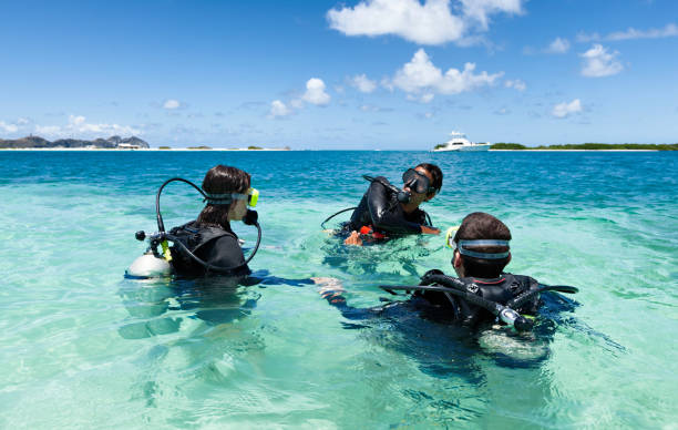 istock Dive master training a couple for first dive in a tropical turquoise island beach. 907892720