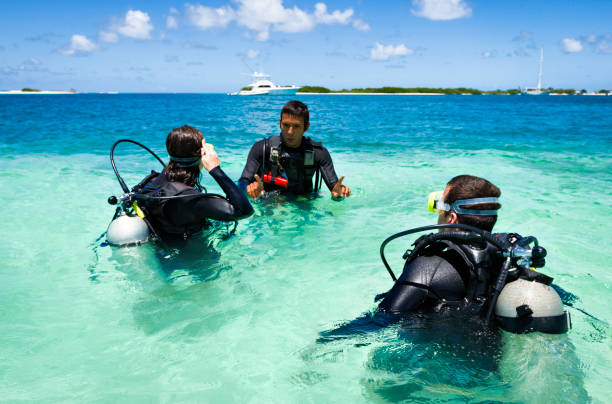 istock Dive master training a couple for first dive in a tropical turquoise island beach. 907893170