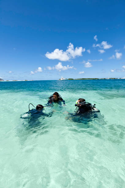 istock Dive master training a couple for first dive in a tropical turquoise island beach. 907893758