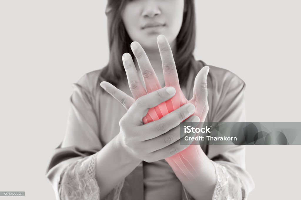 Woman with hand pain Asian woman suffering from pain in bone against gray background, Concept with hand arthritis grimace in pain Arthritis Stock Photo