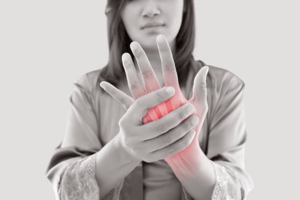 Woman with hand pain Asian woman suffering from pain in bone against gray background, Concept with hand arthritis grimace in pain arthritis stock pictures, royalty-free photos & images
