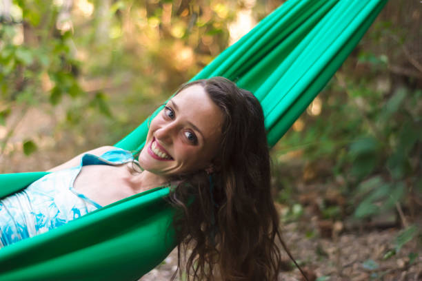 istock Young beautiful woman relaxing in hammock 907900274