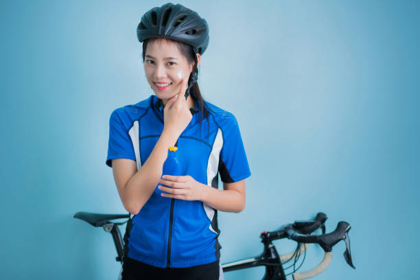 istock Asian women cyclists Applying sunscreen lotion on face 907903702