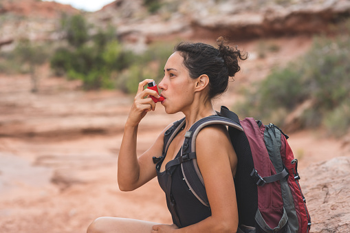 Mujer con asma crónica senderismo en el desierto photo
