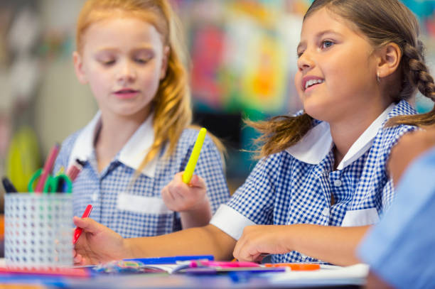 istock Two girl students working in the classroom. 907906762
