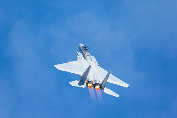 istock F-15 Eagle in a very close view, with afterburners on and clouds in the background 907907574