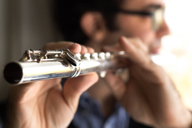 istock A male flutist playing, indoors. 907908548