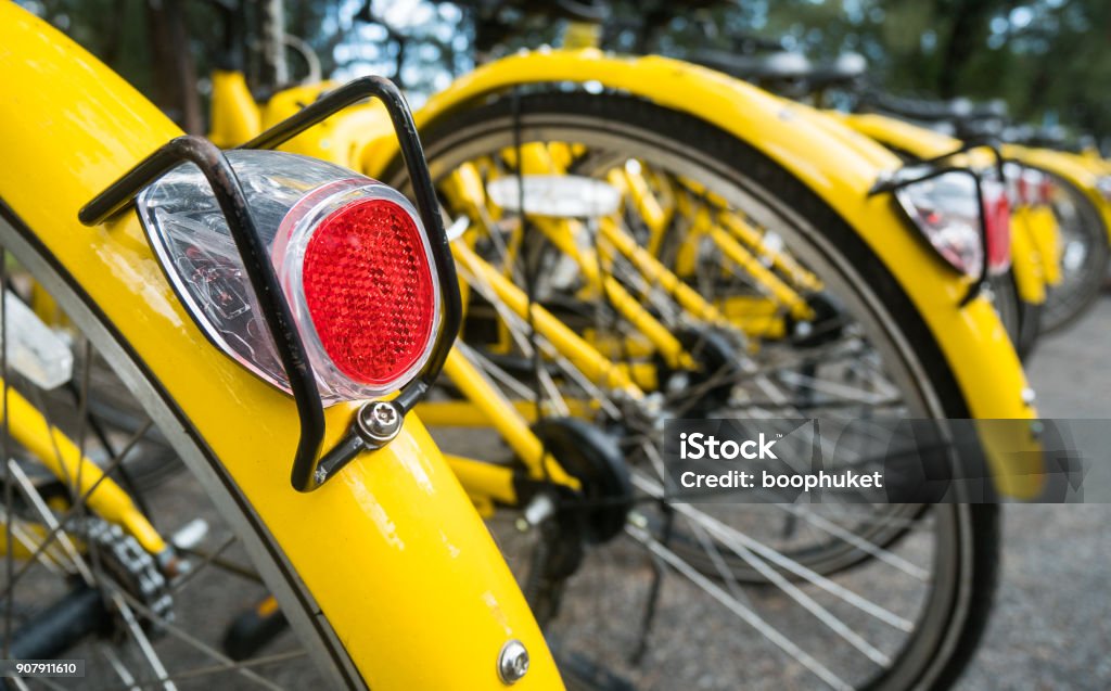 Close up Bicycle tail light on group of yellow vintage bike parking in the Park to service the touristi n bike sharing concept Bicycle Stock Photo