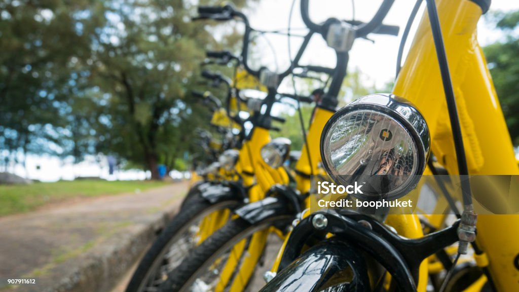 Close up Bicycle headlights on group of yellow vintage bike parking in the Park to service the touristi n bike sharing concept. Bicycle Stock Photo