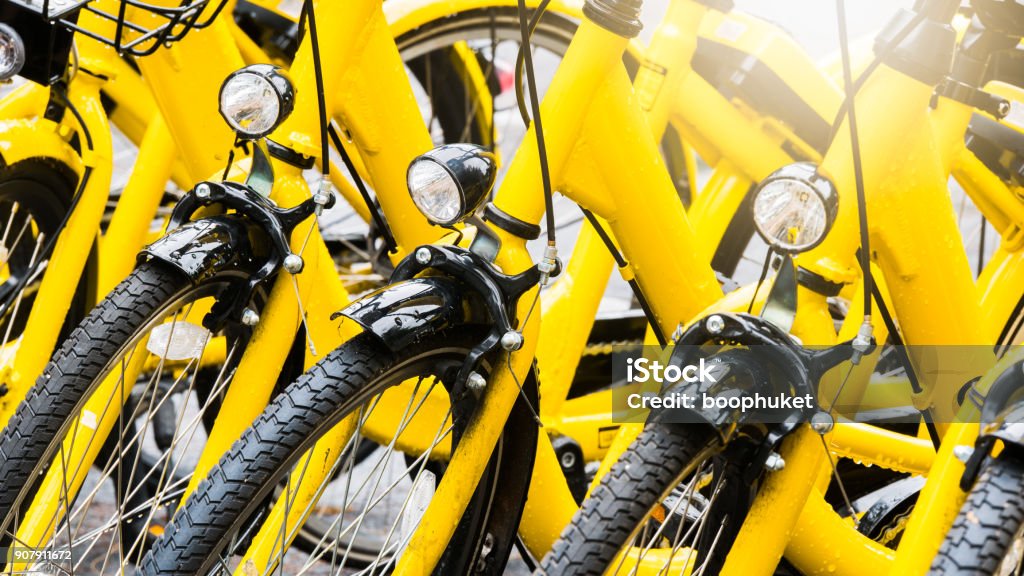 Close up Bicycle headlights on group of yellow vintage bike parking in the Park to service the touristi n bike sharing concept. Bicycle Sharing System Stock Photo