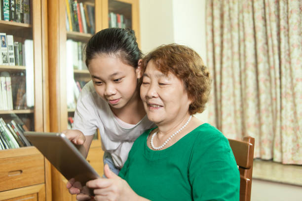 istock Grandmother and granddaughter using digital tablet at home 907911902